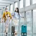 Family,With,Two,Children,Going,On,Holiday,,Wearing,Face,Masks