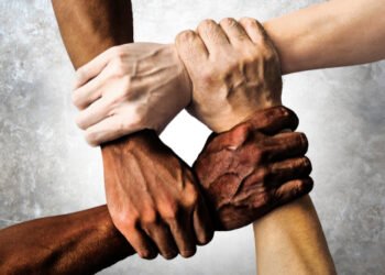 multiracial group with black african American Caucasian and Asian hands holding each other wrist in tolerance unity love and anti racism concept isolated on grunge background