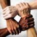 multiracial group with black african American Caucasian and Asian hands holding each other wrist in tolerance unity love and anti racism concept isolated on grunge background