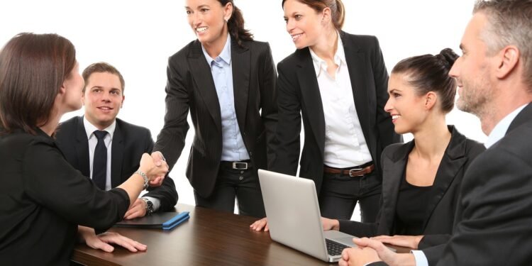 Colleagues shaking hands in office