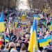 Warsaw, February 26, 2022: Protest against war in Ukraine and Russia's invasion. People marching with flags at demonstration in support of Ukraine