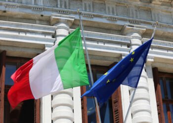 Big,Italian,Flag,And,European,Community,Flag,Flying,Outside,The