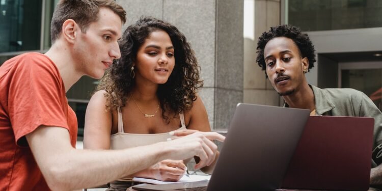 Group of multiethnic coworkers discussing startup project on laptops together