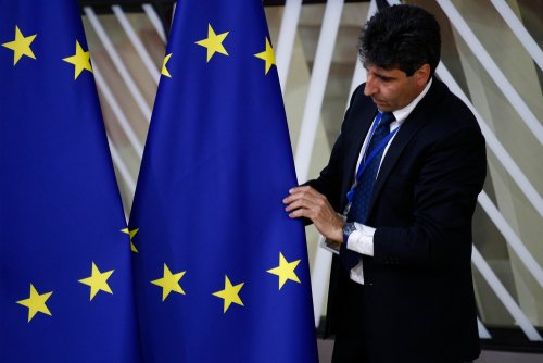 Brussels, Belgium. 28th May 2019.An official adjusts an EU flag in the lobby of the European Council building during the EU Summit.