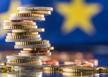 Tower,With,Euro,Coins,And,Flag,Of,European,Union,In