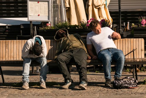 Stockholm, Sweden July 24, 2021 Men sleeping on a bench on Medborgarplatsen.