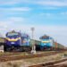 Mariupol, Ukraine - Spring 2021: Two new TE33 locomotives with long freight trains stand at a transit railway station. Train with steel products. Ukrainian railway