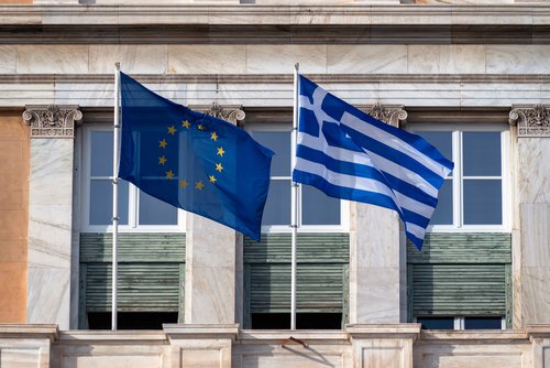 Athens, Attica, Greece - Jan 29, 2021: European Union's and Greece's flags waving in front of the greek parliament neoclassical building. Sunny day