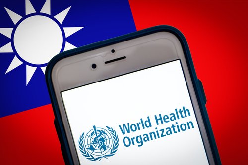 Kumamoto, JAPAN - May 24 2021 : The logo of WHO (The World Health Organization) on smartphone screen on Taiwanese flag bg. Taiwan is not yet invited to WHO despite Coronavirus success