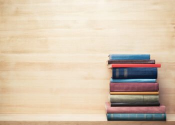 Old books on a wooden shelf.