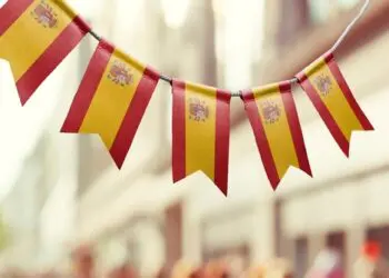 A garland of Spain national flags on an abstract blurred background.