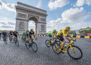 PARIS, FRANCE - JULY 24, 2016 : The road racing cyclist Christopher Froome, wearing the leader's yellow jersey in front of Arc de Triomphe during the Tour de France 2016 on the Champs Elysees Avenue.