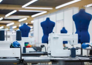 Interior of garment factory . Closes making atelier with several sewing machines. Tailoring industry, fashion designer workshop, industry concept