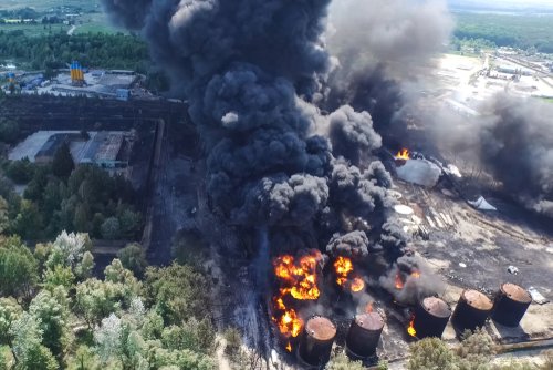 Oil storage fire. The tank farm is burning, black smoke is the combustion of hydrocarbons.