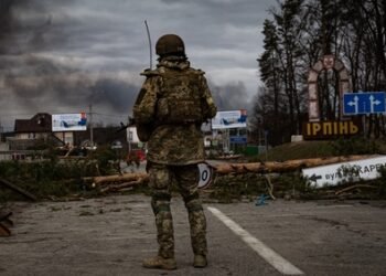 Irpin, Ukraine - 5 March 2022: Ukrainian soldier stands on the check point to the city Irpin near Kyiv during the evacuation of local people under the shelling of the Russian troops.