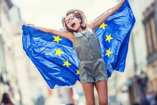 Cute happy young girl with the flag of the European Union.