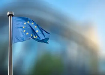 European Union flag in front of the blurred European Parliament in Brussels, Belgium