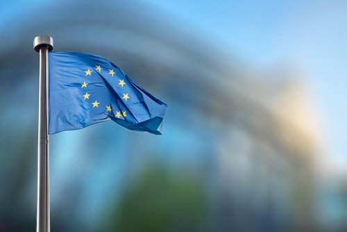 European Union flag in front of the blurred European Parliament in Brussels, Belgium